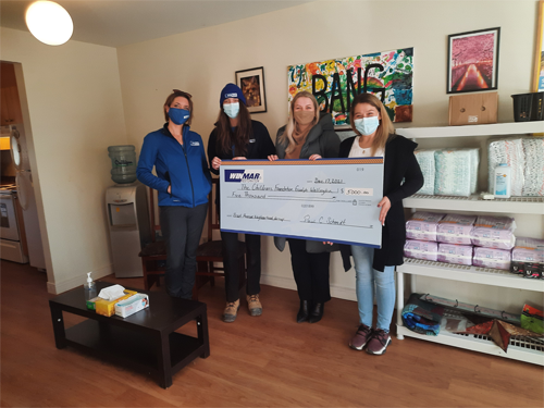 volunteers with a money donation to Guelph Children's Foundation